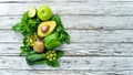 Fresh organic green fruits and vegetables. Avocado, kiwi, onion, lime, parsley. Organic food. Rustic style. Top view. Royalty Free Stock Photo