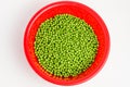 Fresh organic green peas in a large red round bowl isolated on white, top view Royalty Free Stock Photo