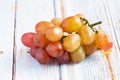 Fresh organic group of sweet juicy and healthy grapes fruit on white wooden board background Royalty Free Stock Photo