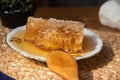 Fresh organic honeycomb with wooden spoon on wooden table at home