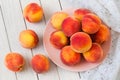 Fresh organic peaches in a plate on a white wooden table Royalty Free Stock Photo