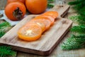 Fresh organic persimmon with slices on wooden board Royalty Free Stock Photo
