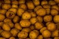Fresh organic potato stand out among many large background potatoes in the market. Heap of potato root Royalty Free Stock Photo
