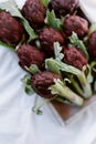 Fresh organic purple artichokes in a box