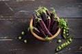 Fresh organic purple green peas in a wooden bowl on rustic wooden table. Royalty Free Stock Photo