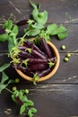 Fresh organic purple green peas in a wooden bowl on rustic wooden table. Royalty Free Stock Photo