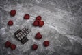 Fresh organic raspberries and two bars of organic 70% cocoa dark chocolate on a stone background with copy space Royalty Free Stock Photo