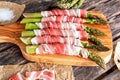 Fresh Organic raw Bacon Wrapped Asparagus on wooden table. Royalty Free Stock Photo