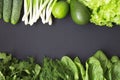Fresh organic raw produce. Green toned vegetables and fruits on dark background.