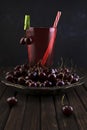 Fresh organic red cherry fruits in a vintage silver plate and a glass of cherry juice on an old dark table made of wooden boards Royalty Free Stock Photo