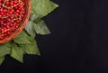 Fresh, organic red currant in a basket on a black background. Juicy bright red berries. Ripe and healthful tasteful currant. Royalty Free Stock Photo