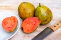 Fresh organic red guavas fruit cut in half on a wooden board. Exotic fruits, healthy eating concept