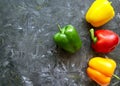 Fresh organic ripe bell peppers or capsicum on grey table, top view. Fresh vegetables bell red, yellow, Green, orange peppers Royalty Free Stock Photo