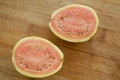 Fresh organic ripe red guavas fruit cut in half on a wooden board. Exotic fruits, healthy eating concept