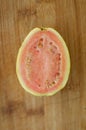 Fresh organic ripe red guavas fruit cut in half on a wooden board. Exotic fruits, healthy eating concept