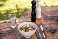 Fresh organic salad served on a bowl with mixed green leaves, eggs, black olives and tomato on a wooden rustic table with cutlery Royalty Free Stock Photo