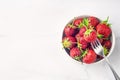 Fresh organic strawberry in the white bowl and fork, on the white background Royalty Free Stock Photo