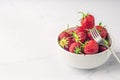 Fresh organic strawberry in the white bowl and fork, on the white background Royalty Free Stock Photo