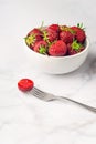 Fresh organic strawberry in the white bowl and fork, on the white background Royalty Free Stock Photo