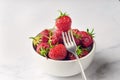 Fresh organic strawberry in the white bowl and fork, on the white background Royalty Free Stock Photo