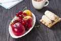 Fresh organic summer berries and fruits in a white plate on a black background Royalty Free Stock Photo