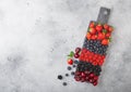 Fresh organic summer berries mix on black marble board on light kitchen table background. Raspberries, strawberries, blueberries, Royalty Free Stock Photo