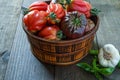 Fresh Organic Tomatoes in a basket and basil with garlik on a wooden table. Royalty Free Stock Photo