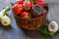 Fresh Organic Tomatoes in a basket and basil with garlik on a wooden table. Royalty Free Stock Photo