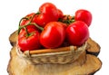 Fresh organic tomatoes with water drops in a basket isolated on white. Close up Royalty Free Stock Photo