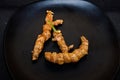 Fresh organic turmeric roots in a black plate