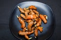 Fresh organic turmeric roots in a black plate