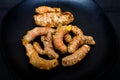 Fresh organic turmeric roots in a black plate