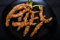 Fresh organic turmeric roots in a black plate