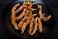 Fresh organic turmeric roots in a black plate