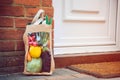 Fresh organic vegetable delivery concept. Reusable bio eco sackcloth fabric bag packaging near brick wall house threshold. Local