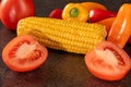Fresh organic vegetable mix with tomatoes, bell peppers, and corn on black background Royalty Free Stock Photo