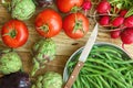 Fresh Organic Vegetables Artichokes Green Beans Tomatoes Red Radish Broccoli Eggplants on Weathered Wood Garden Kitchen Table Royalty Free Stock Photo