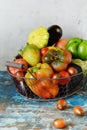 Fresh organic vegetables in a basket on a gray background. Harvest of pepper, tomatoes, eggplant and mini pumpkin patissons. Royalty Free Stock Photo