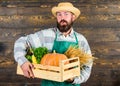 Fresh organic vegetables box. Farmer hipster straw hat deliver fresh vegetables. Man cheerful bearded farmer wear apron Royalty Free Stock Photo