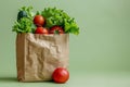 Fresh organic vegetables and fruits in a recycled paper shopping bag on the green background with copy space. Healthy Royalty Free Stock Photo