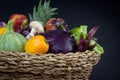 FRESH AND ORGANIC VEGETABLES AND FRUITS IN WOVEN BASKET ISOLATED ON BLACK BACKGROUND