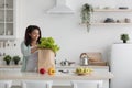 Fresh organic vegetables, greens and fruits in eco brown paper bag on white table in kitchen Royalty Free Stock Photo