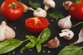 Fresh tomatoes and garlic closeup on dark rustic wood Royalty Free Stock Photo