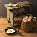 Fresh organic village eggs on wooden table, healthy food,  village food. black pan with fried egg. small bench background Royalty Free Stock Photo