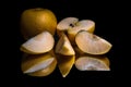 Fresh organic yellow apple whole and sliced with reflection on shiny black background Royalty Free Stock Photo