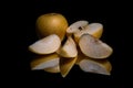 Fresh organic yellow apple whole and sliced with reflection on shiny black background Royalty Free Stock Photo