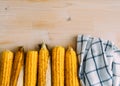 Fresh organic yellow sweet corn with towel on wooden table. Top view