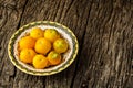 Fresh, organic yellow tomatoes on yellow plate over rustic wooden background with copy space. Flat lay Royalty Free Stock Photo