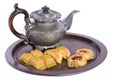 Fresh oriental pastries, so-called baklava, lie on a tray made of hammered copper with an old tin teapot behind it, cut out Royalty Free Stock Photo