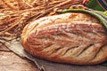 Fresh oven baked homemade sourdough bread in folklore bag. Bulgarian traditions and symbol of farmland field and farmer